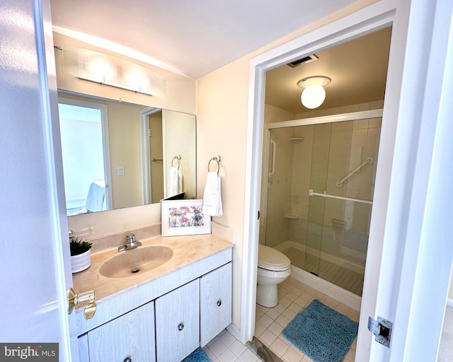 bathroom with tile patterned floors, vanity, toilet, and a shower with door