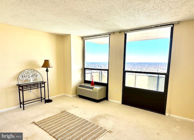 sitting room featuring carpet flooring, a wall mounted AC, and a textured ceiling