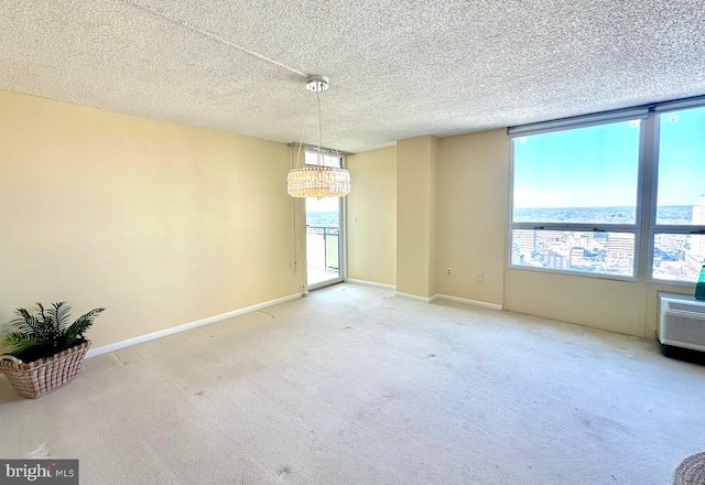 empty room with carpet, a water view, a textured ceiling, and a wealth of natural light