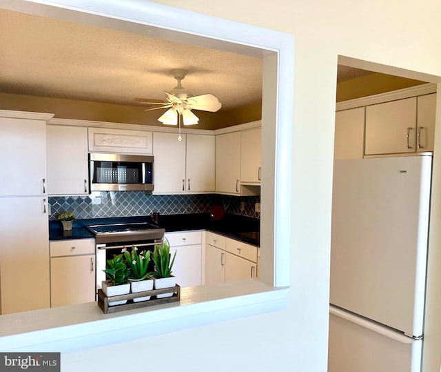 kitchen with white refrigerator, ceiling fan, range with electric stovetop, a textured ceiling, and tasteful backsplash