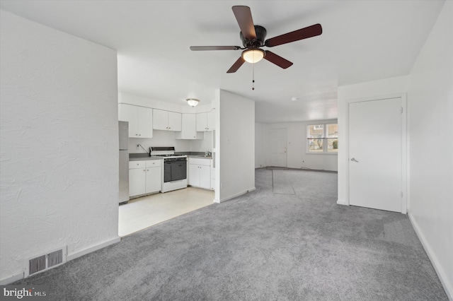 unfurnished living room with ceiling fan, sink, and light carpet