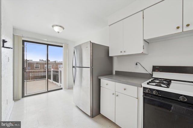 kitchen with stainless steel refrigerator, white range with gas cooktop, and white cabinets