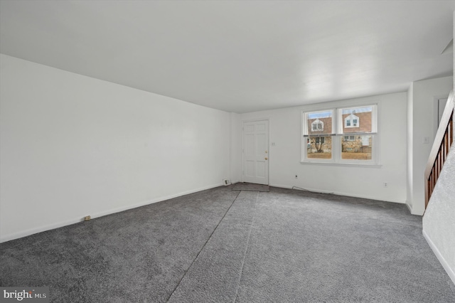 unfurnished room featuring dark colored carpet