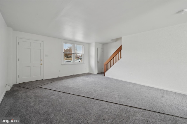 unfurnished living room featuring dark colored carpet