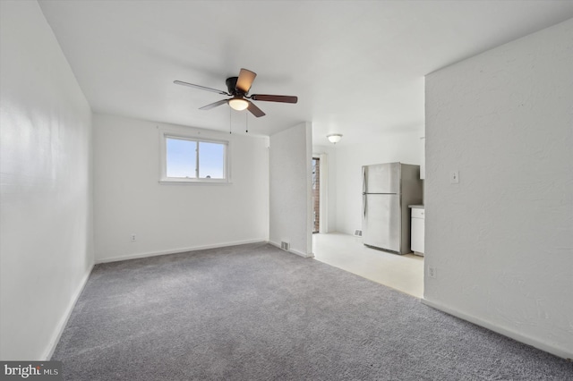 carpeted empty room featuring ceiling fan