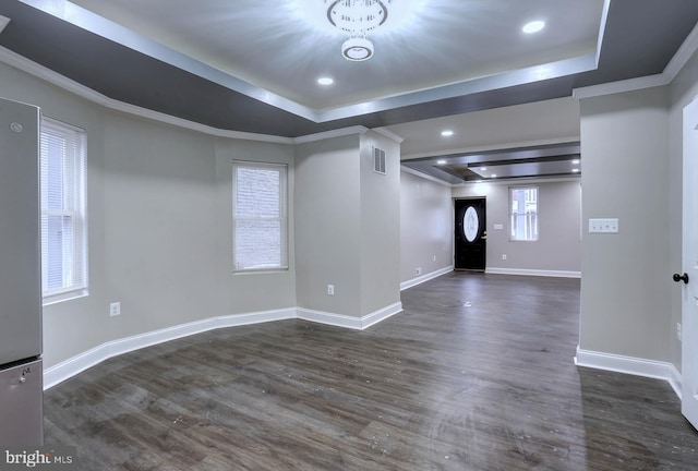 entrance foyer featuring dark hardwood / wood-style floors, a tray ceiling, and ornamental molding