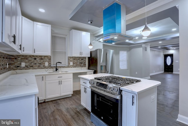 kitchen with decorative light fixtures, sink, island exhaust hood, stainless steel appliances, and white cabinets