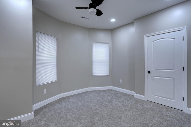 carpeted spare room featuring ceiling fan