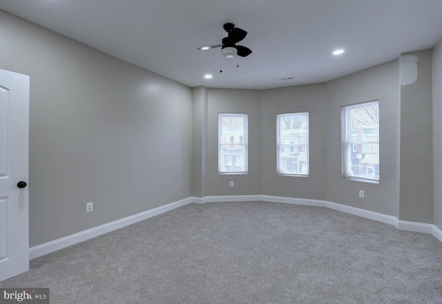 carpeted empty room featuring ceiling fan and a healthy amount of sunlight