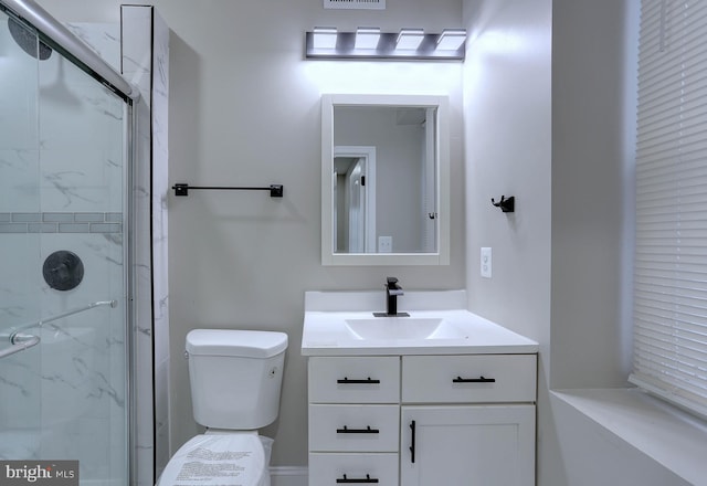 bathroom with toilet, a shower with shower door, and vanity