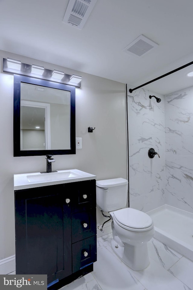 bathroom featuring toilet, vanity, and a tile shower