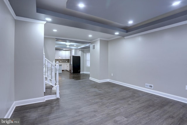 interior space with dark wood-type flooring, ornamental molding, and stainless steel fridge