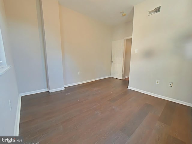 unfurnished room featuring dark wood-type flooring