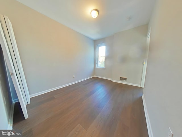 unfurnished room featuring dark wood-type flooring