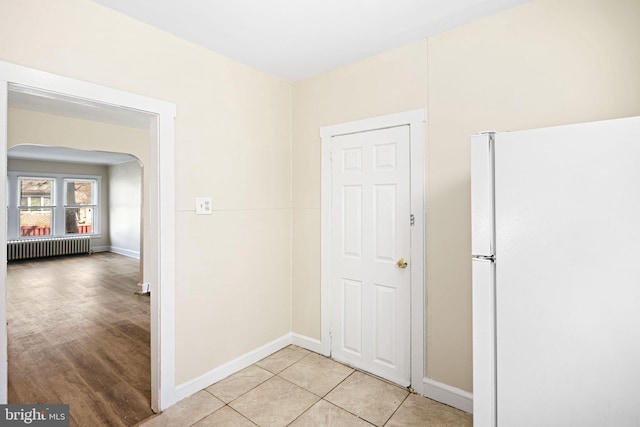 hall with radiator and light tile patterned flooring