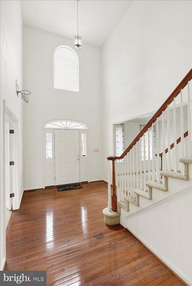 foyer entrance with a towering ceiling and hardwood / wood-style flooring