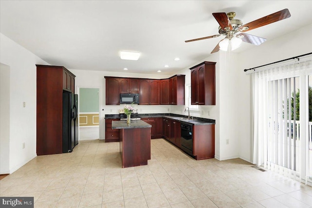 kitchen with black appliances, sink, ceiling fan, light tile patterned floors, and a kitchen island