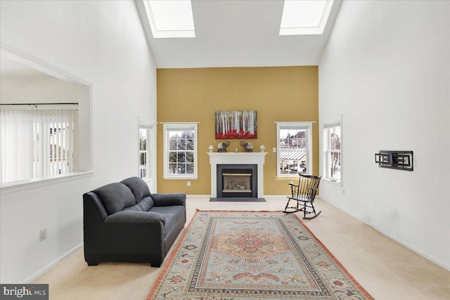 living room featuring a skylight, carpet floors, and high vaulted ceiling