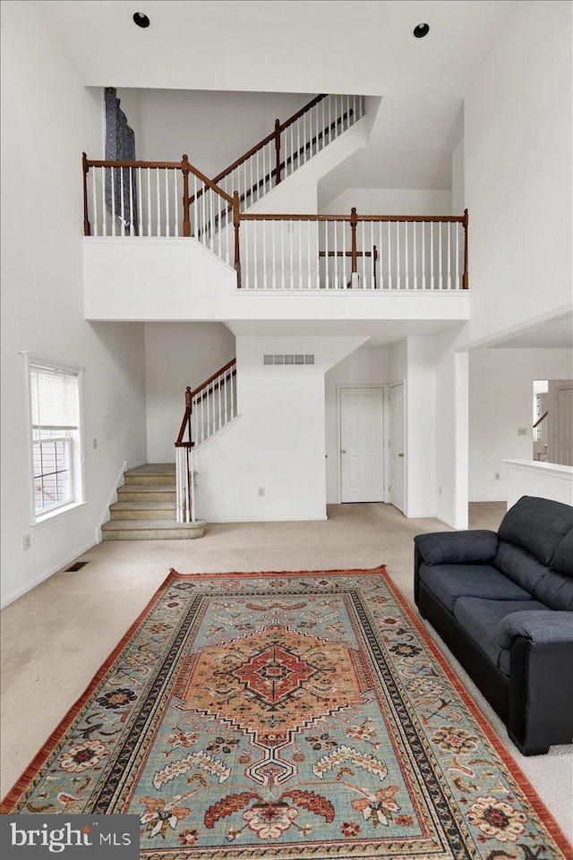 carpeted living room with a towering ceiling