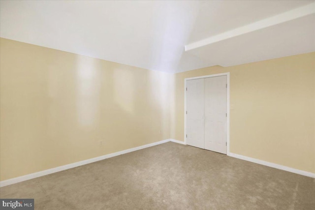 unfurnished room with carpet flooring and lofted ceiling