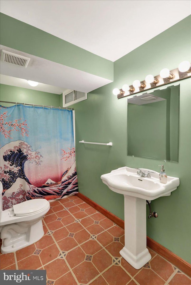 bathroom featuring tile patterned floors, toilet, and curtained shower