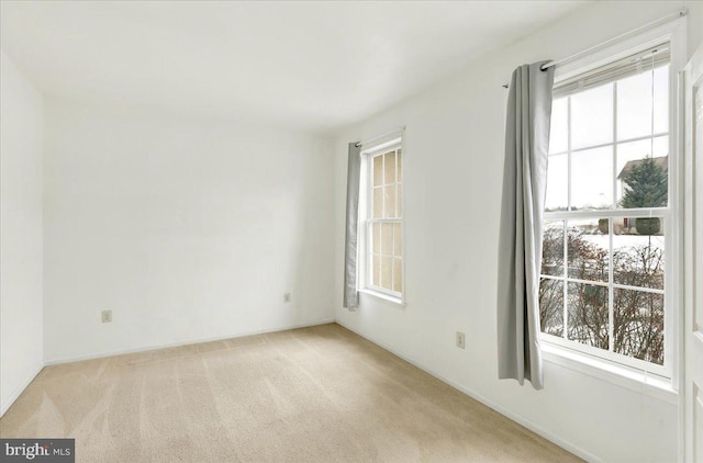 carpeted spare room featuring a healthy amount of sunlight