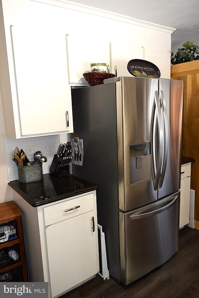 kitchen featuring dark wood-type flooring, dark stone counters, white cabinets, decorative backsplash, and stainless steel fridge with ice dispenser