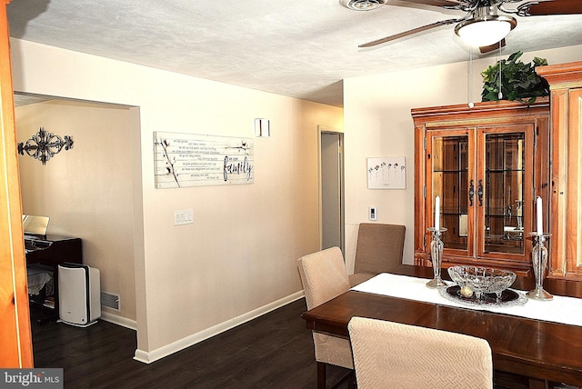 dining space with ceiling fan, dark wood-type flooring, and a textured ceiling