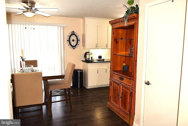 kitchen featuring dark hardwood / wood-style flooring, white cabinetry, ceiling fan, and backsplash