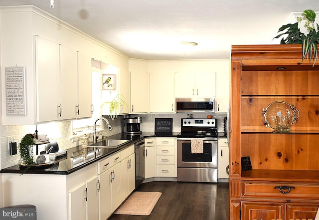 kitchen with appliances with stainless steel finishes, tasteful backsplash, white cabinetry, and sink