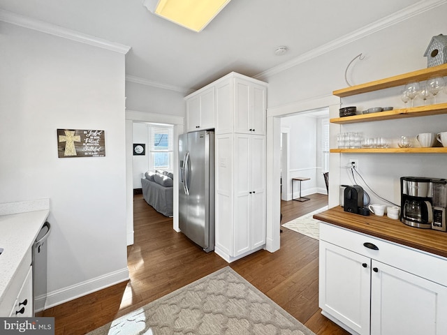 kitchen featuring stainless steel appliances, white cabinetry, dark wood-type flooring, and crown molding