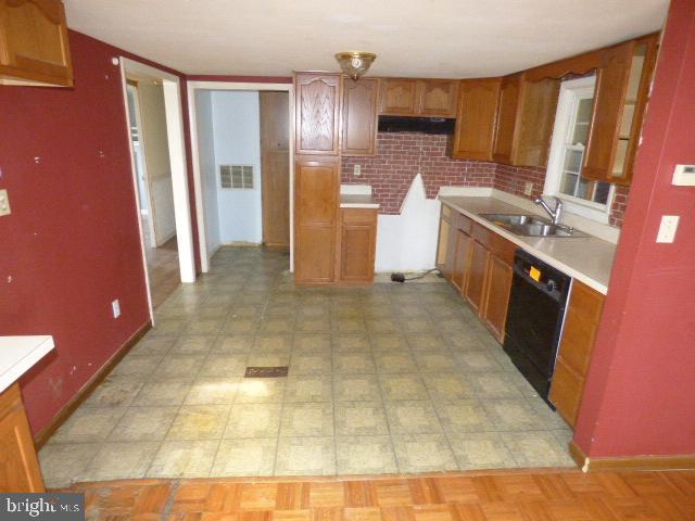 kitchen featuring tasteful backsplash, sink, and black dishwasher