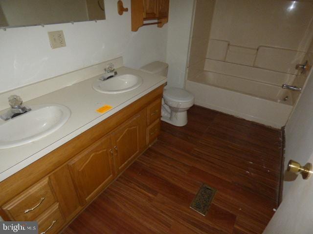 full bathroom with wood-type flooring, vanity, toilet, and shower / bathtub combination