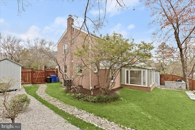 rear view of house featuring a storage unit and a lawn