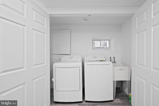 laundry area with independent washer and dryer and hardwood / wood-style flooring