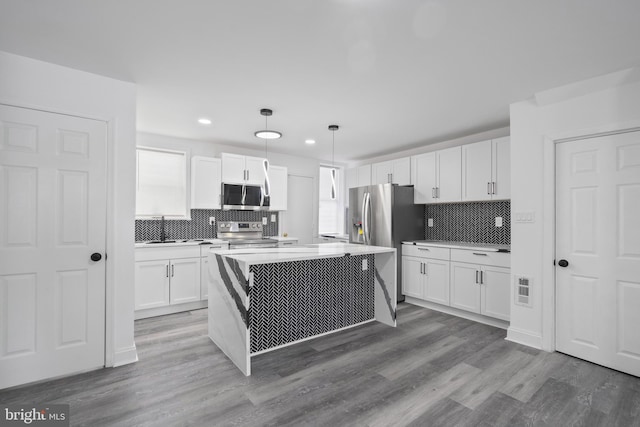 kitchen with stainless steel appliances, dark wood-type flooring, sink, decorative light fixtures, and white cabinets