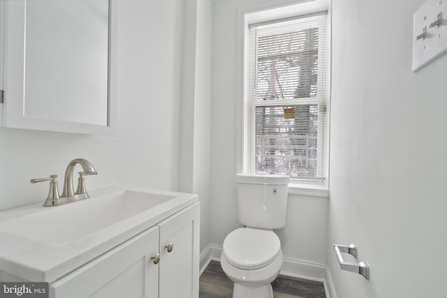 bathroom featuring vanity, hardwood / wood-style flooring, toilet, and a wealth of natural light