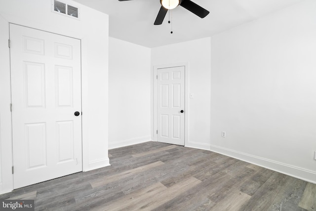 unfurnished bedroom featuring ceiling fan and dark wood-type flooring