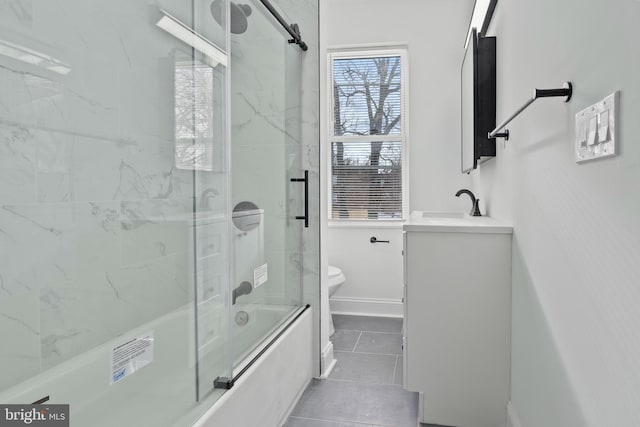 full bathroom with tile patterned floors, vanity, toilet, and shower / bath combination with glass door