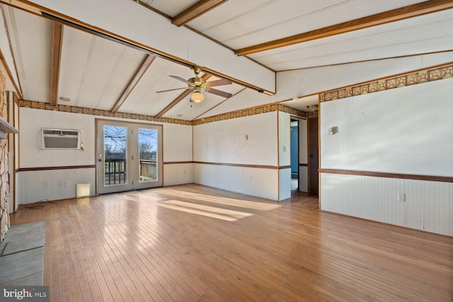 spare room with ceiling fan, lofted ceiling with beams, light hardwood / wood-style floors, and a wall unit AC