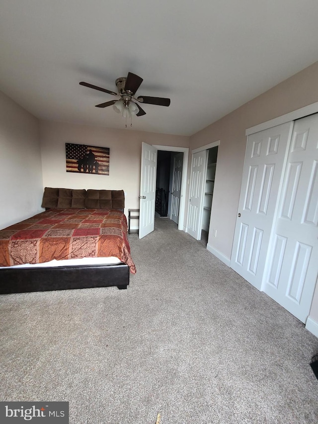 unfurnished bedroom featuring ceiling fan, carpet, and two closets