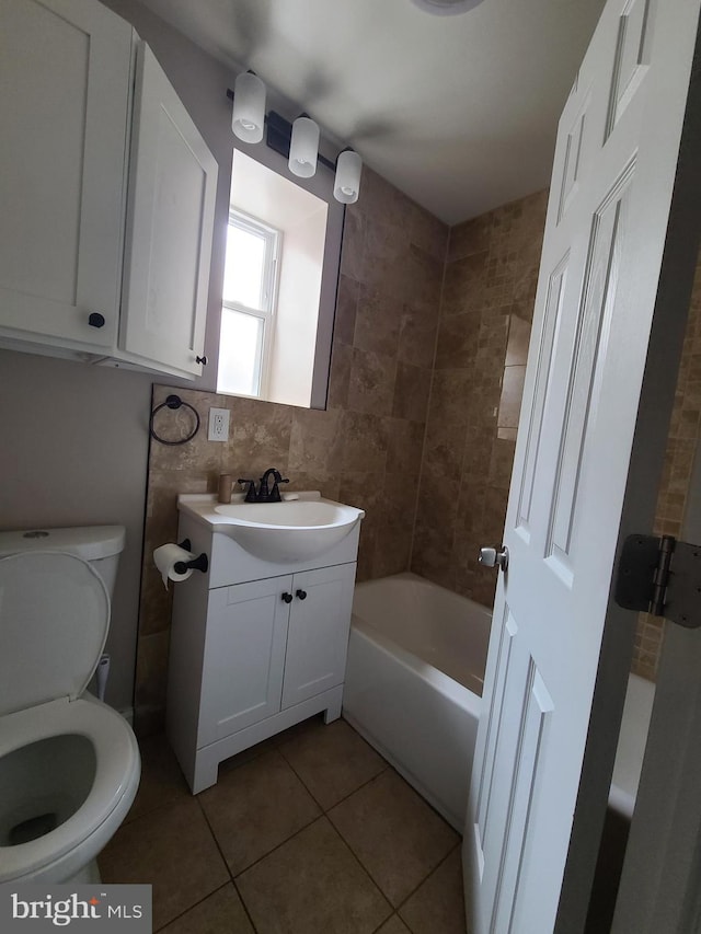 bathroom featuring tile patterned flooring, vanity, tasteful backsplash, and toilet