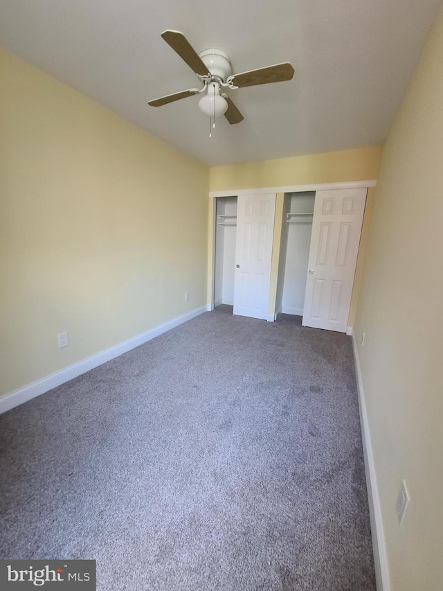 unfurnished bedroom with ceiling fan, a closet, and dark colored carpet