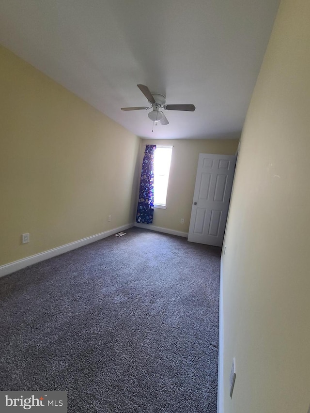 spare room featuring ceiling fan and carpet floors