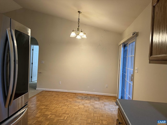 interior space featuring a notable chandelier, lofted ceiling, and light parquet floors