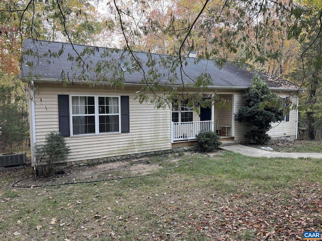 view of front facade featuring covered porch, central air condition unit, and a front yard