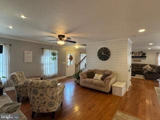 living room with ornamental molding, ceiling fan, and dark wood-type flooring