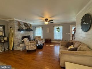 living room with ceiling fan, a healthy amount of sunlight, and ornamental molding