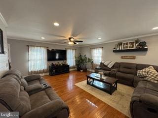 living room featuring hardwood / wood-style flooring, ceiling fan, and crown molding