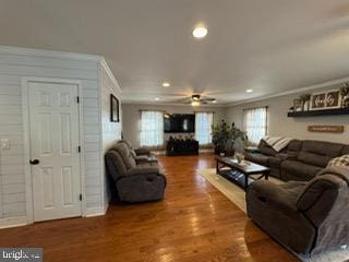 living room with hardwood / wood-style flooring, ceiling fan, and ornamental molding